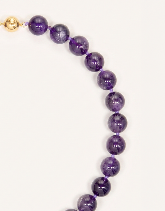 A 16-inch Natural Amethyst Necklace featuring polished 12mm beads in rich violet and lavender shades.