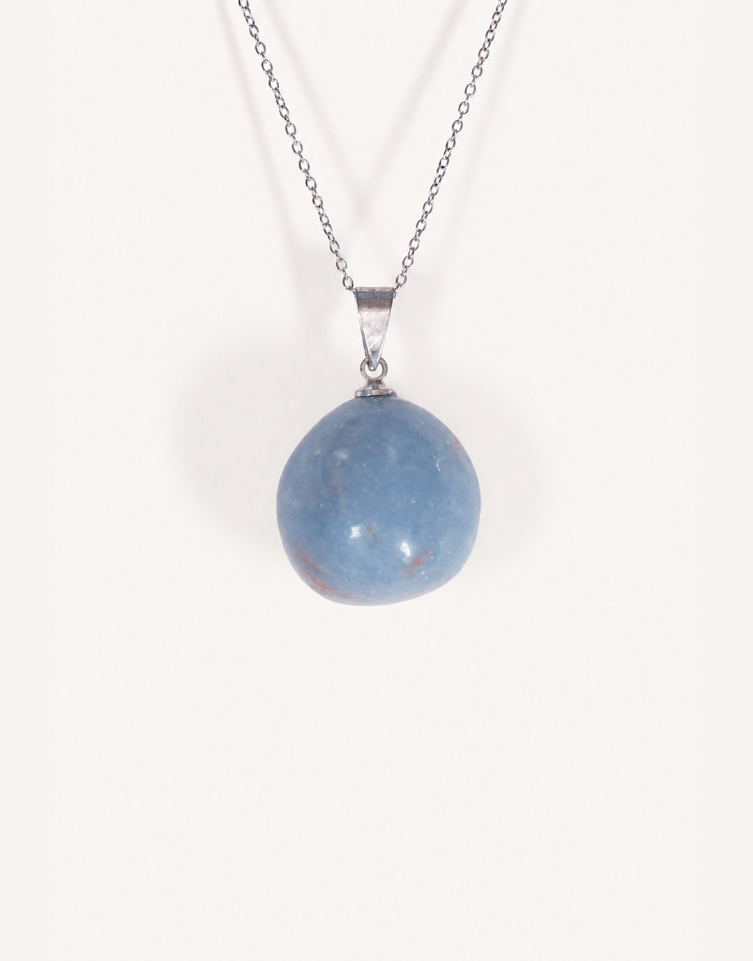 A Natural Angelite Pendant featuring a smooth powder-blue tumbled stone on an 18-inch stainless steel chain.