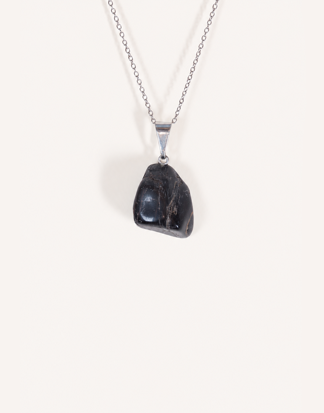 A Natural Black Tourmaline Pendant displaying a smooth, glossy jet-black tumbled stone on an 18-inch stainless steel chain.