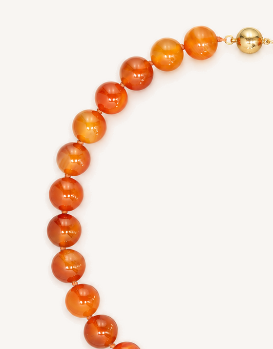 A 16-inch Natural Carnelian Necklace crafted with smooth 12mm beads in glowing shades of burnt orange, amber, and deep crimson.