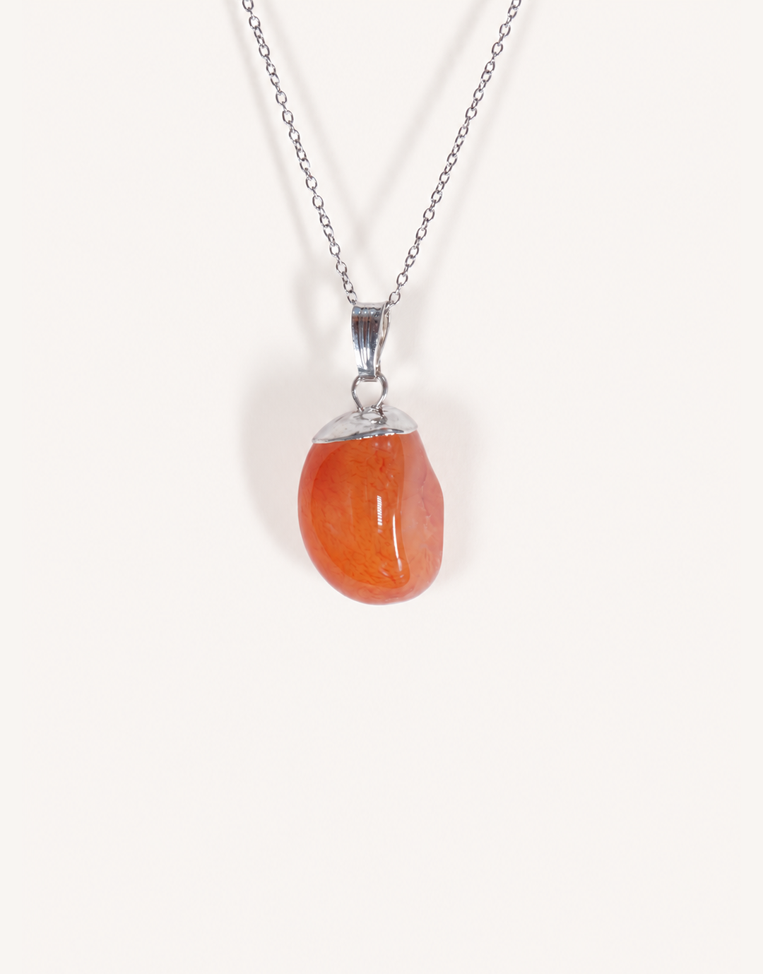 A Natural Carnelian Pendant featuring a smooth, polished orange tumbled stone on an 18-inch stainless steel chain.
