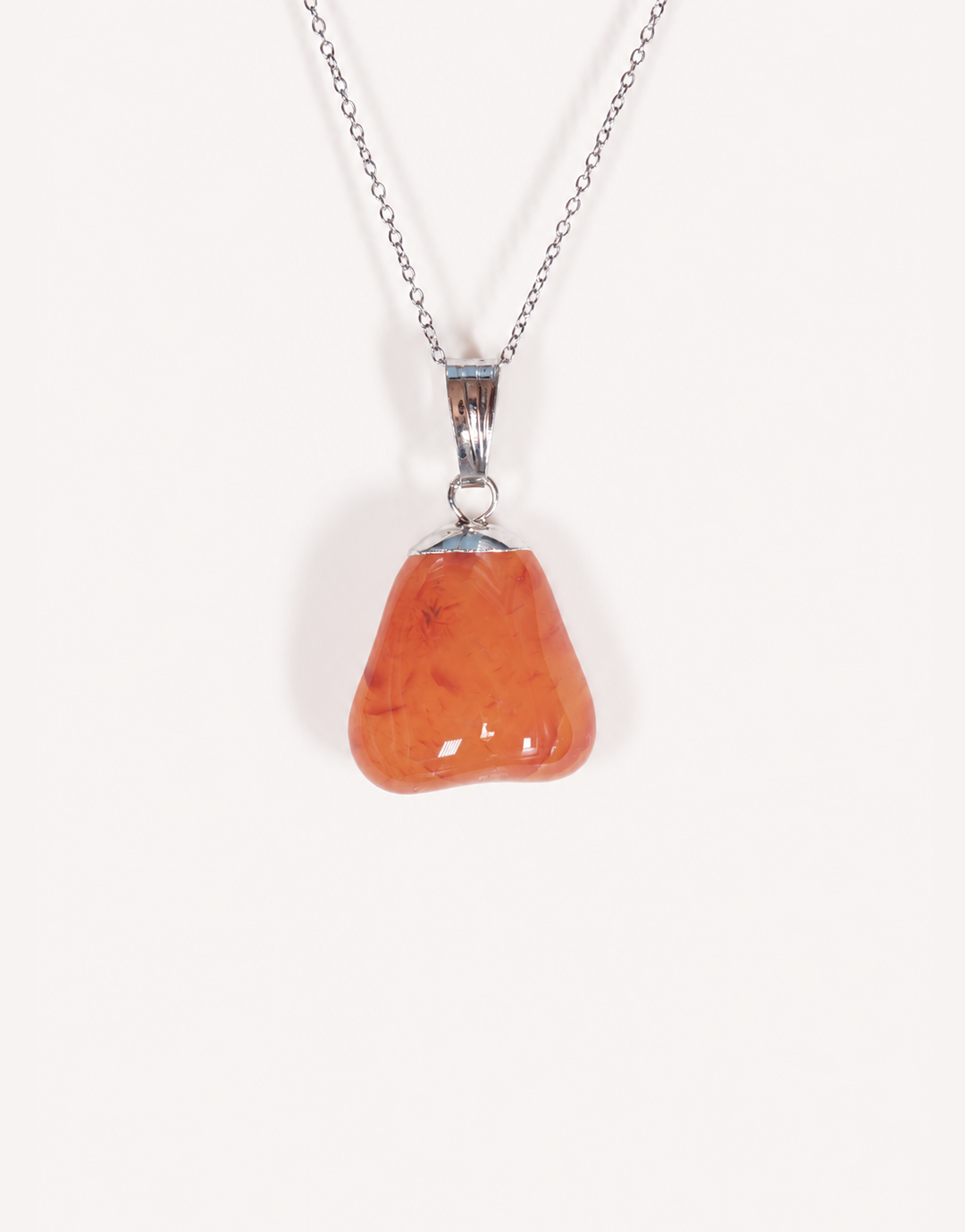 A Natural Carnelian Pendant featuring a smooth, polished orange tumbled stone on an 18-inch stainless steel chain.