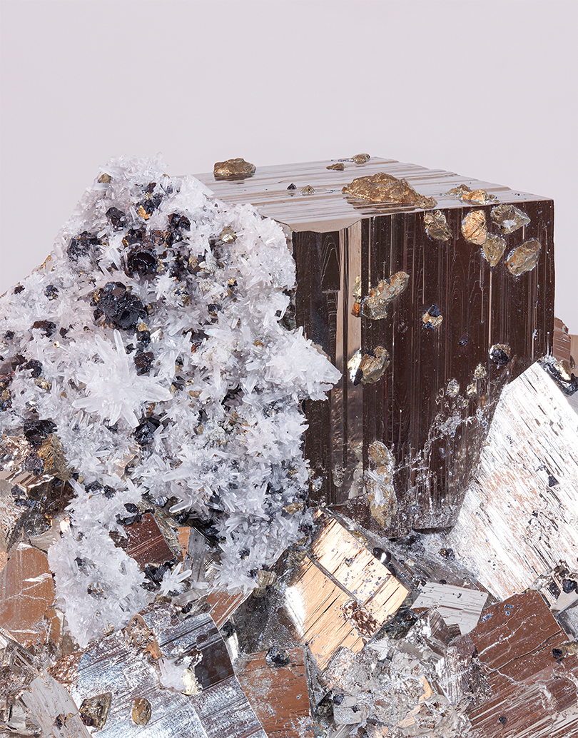 A lustrous cubic Pyrite mineral specimen with white quartz needles, chalcopyrite, and dark sphalerite inclusions from Huanzala Mine, Peru, measuring 9 x 13 cm.
