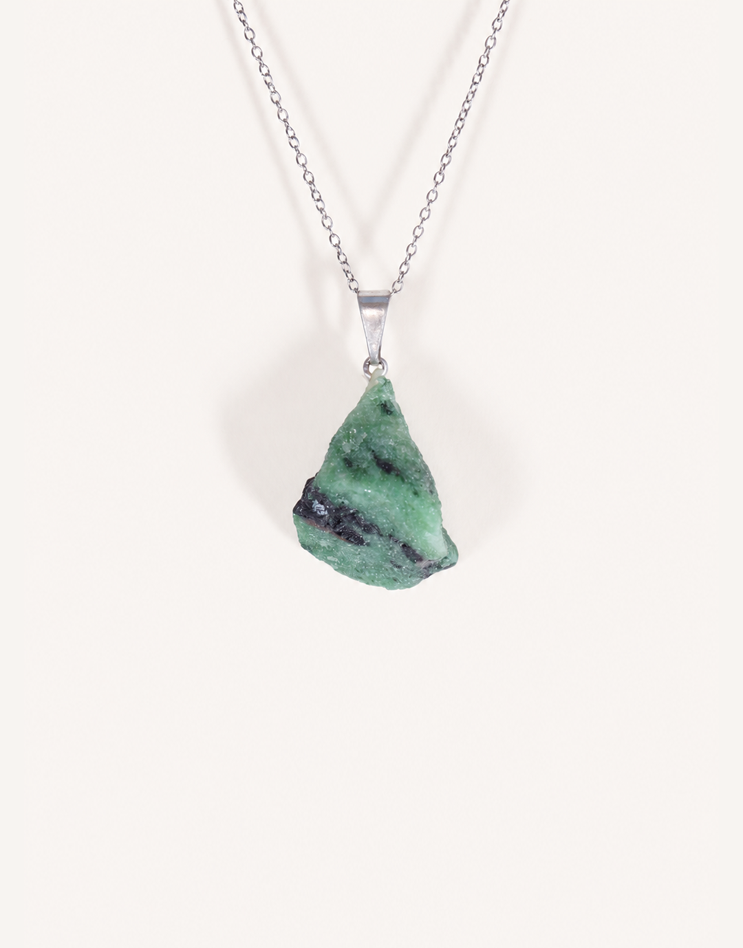 A Natural Raw Zoisite Pendant featuring a rough green crystal stone with black inclusions and a magenta ruby matrix spot on an 18-inch stainless steel chain.