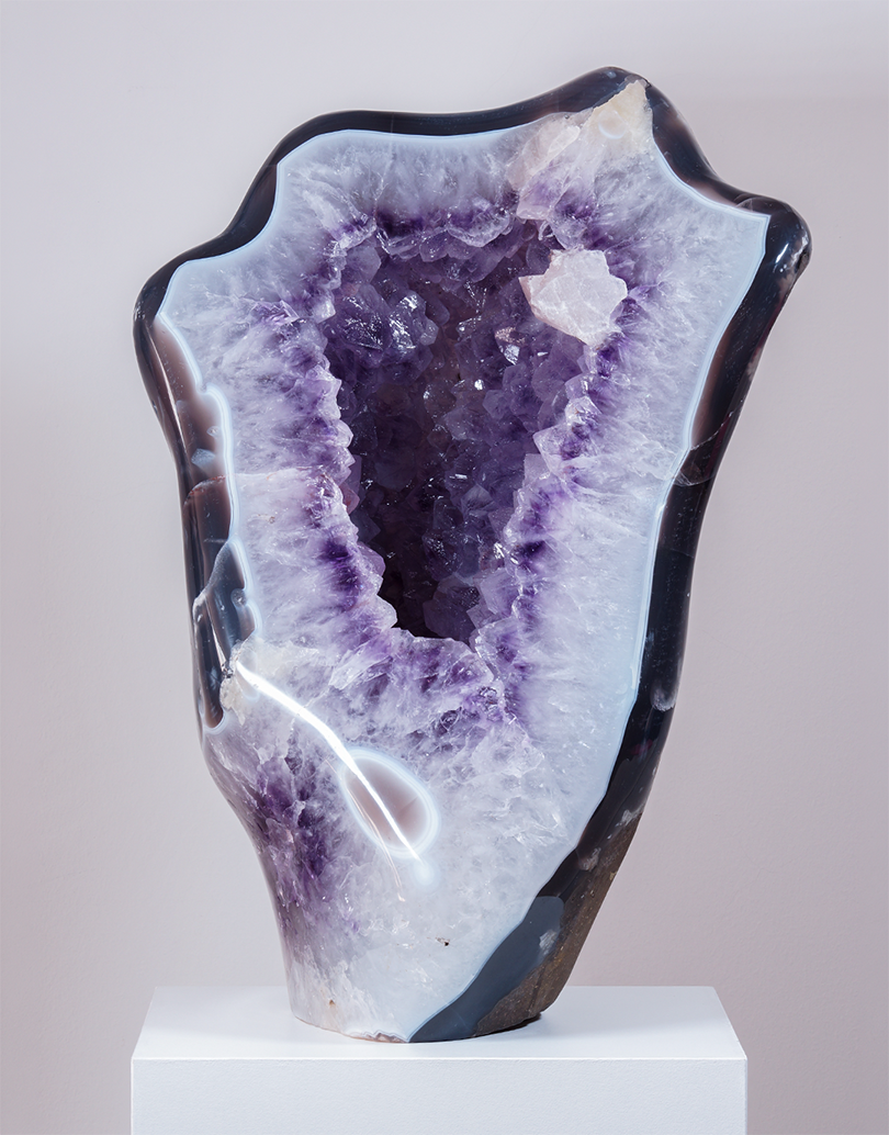 An 11 kg Uruguayan Amethyst Freeform Sculpture standing 35 cm tall with a polished agate border surrounding a purple crystal cavity.