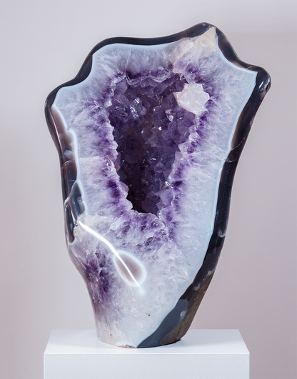 An 11 kg Uruguayan Amethyst Freeform Sculpture standing 35 cm tall with a polished agate border surrounding a purple crystal cavity.