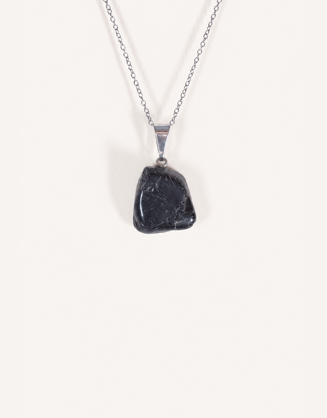 A Natural Black Tourmaline Pendant displaying a smooth, glossy jet-black tumbled stone on an 18-inch stainless steel chain.