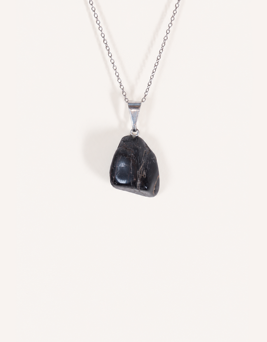 A Natural Black Tourmaline Pendant displaying a smooth, glossy jet-black tumbled stone on an 18-inch stainless steel chain.