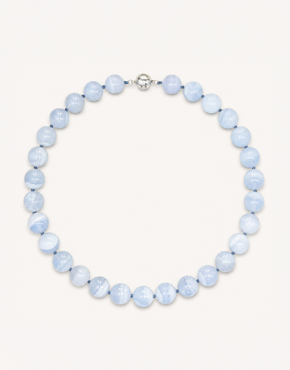 A 16-inch Natural Blue Lace Agate Necklace featuring smooth 12mm light blue beads with delicate white striped patterns.
