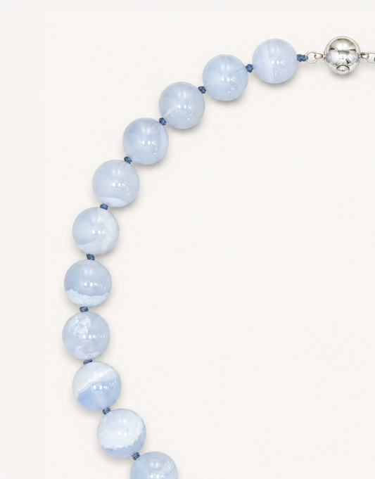 A 16-inch Natural Blue Lace Agate Necklace featuring smooth 12mm light blue beads with delicate white striped patterns.