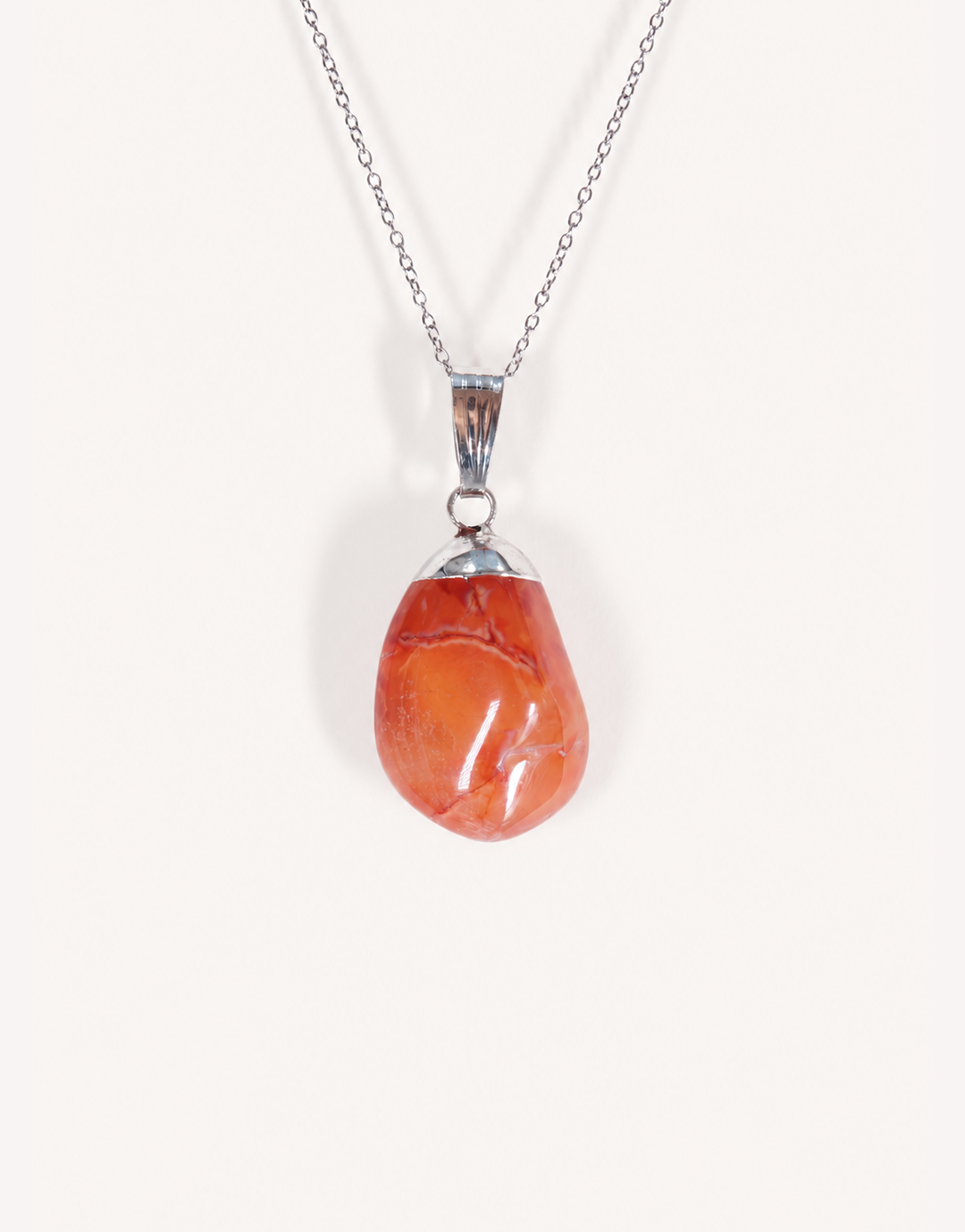 A Natural Carnelian Pendant featuring a smooth, polished orange tumbled stone on an 18-inch stainless steel chain.