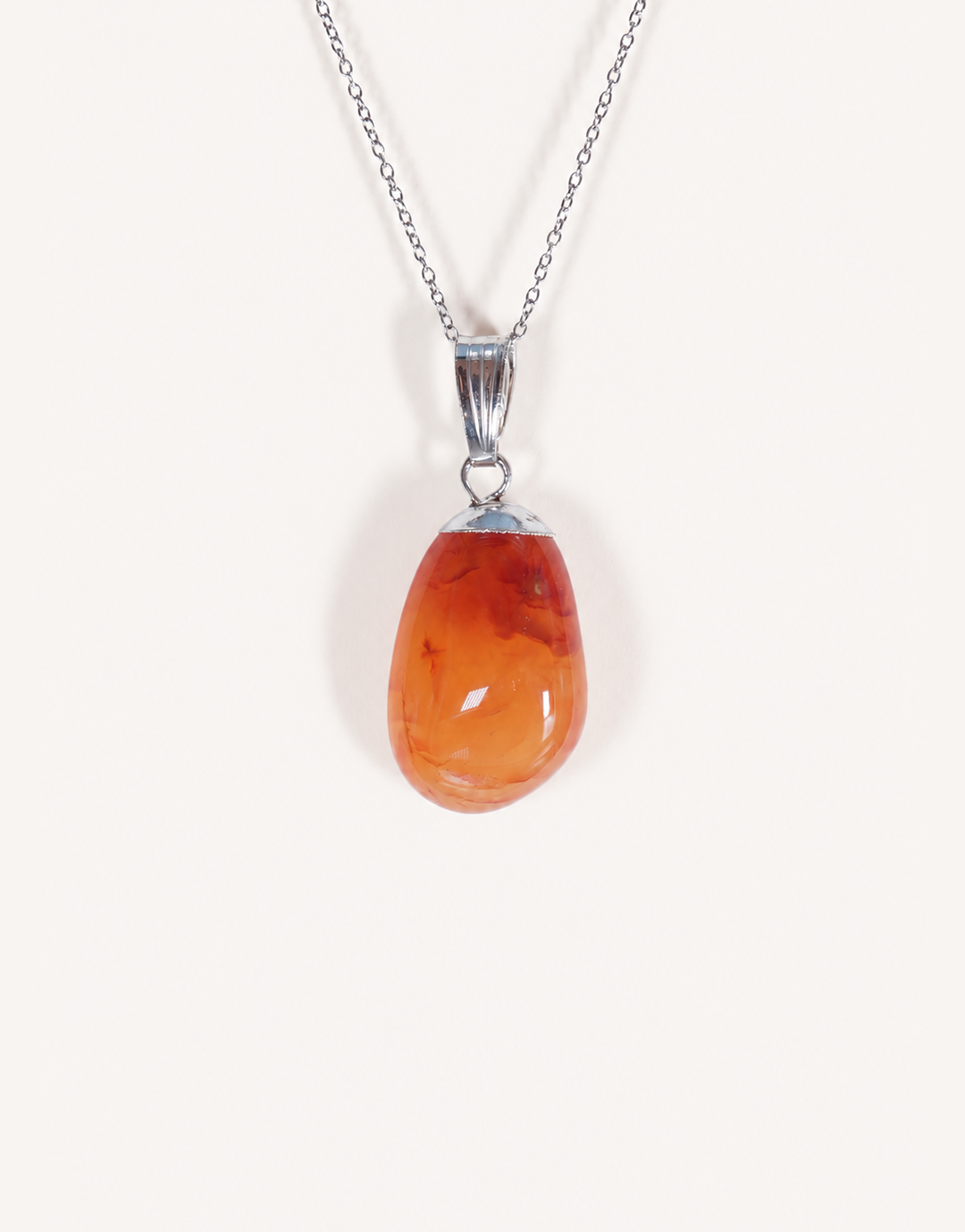 A Natural Carnelian Pendant featuring a smooth, polished orange tumbled stone on an 18-inch stainless steel chain.