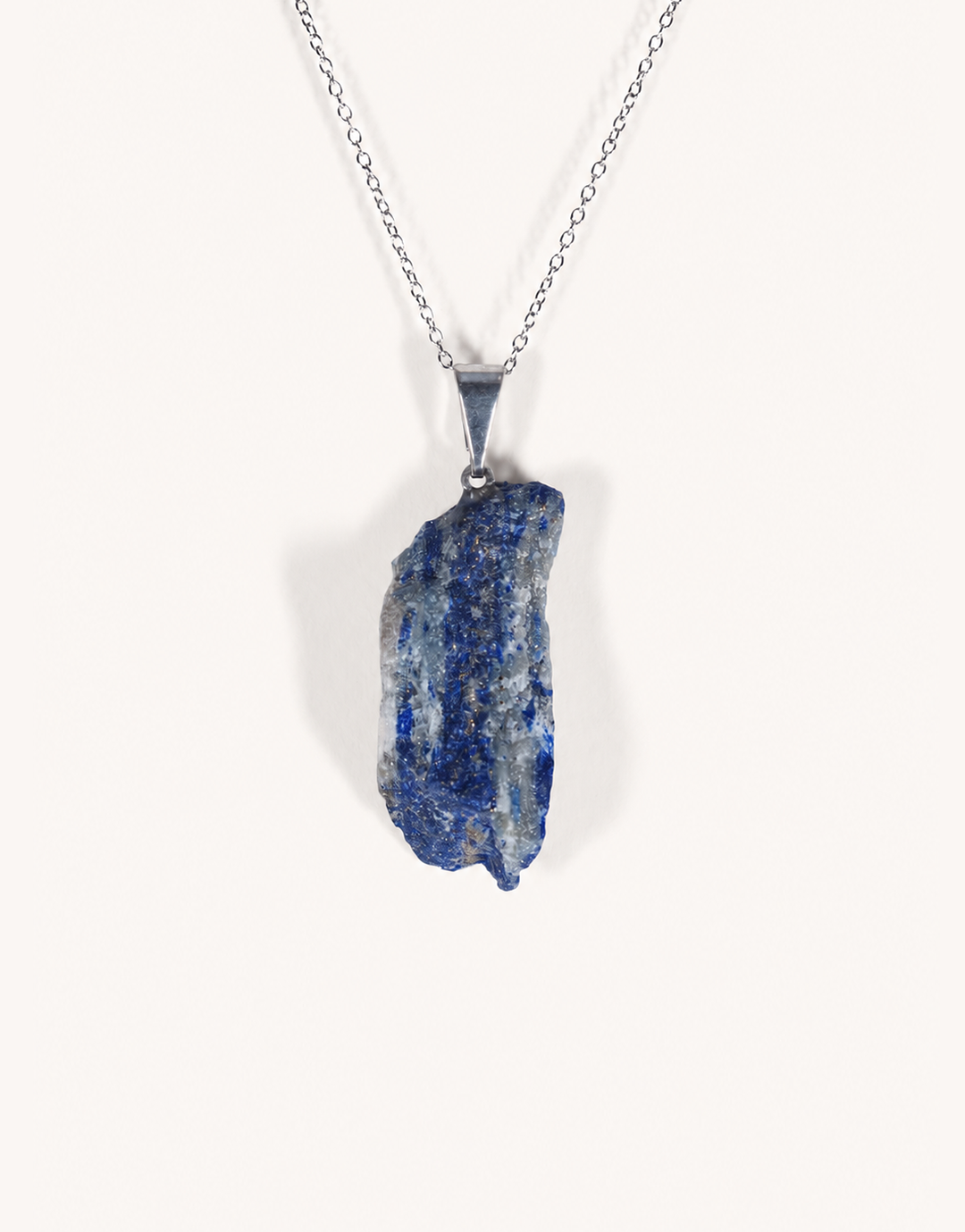 A Natural Raw Lapis Lazuli Pendant featuring an unpolished deep blue stone with golden pyrite flecks on an 18-inch stainless steel chain.