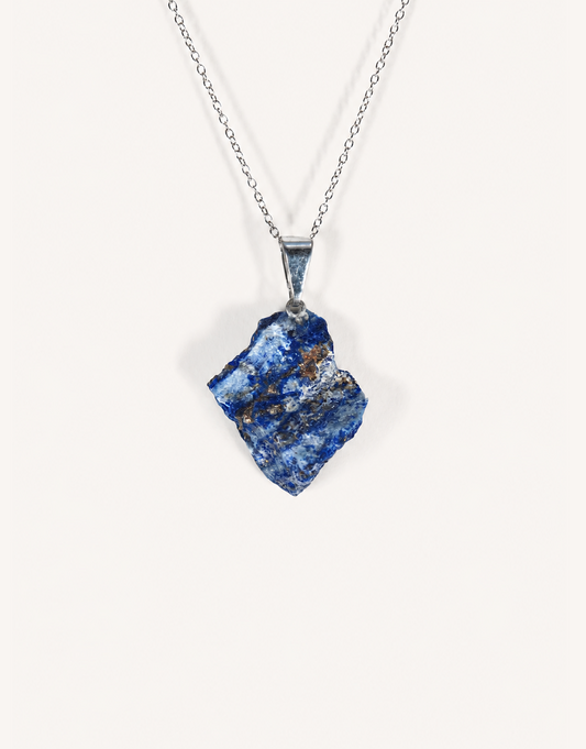 A Natural Raw Lapis Lazuli Pendant featuring an unpolished deep blue stone with golden pyrite flecks on an 18-inch stainless steel chain.