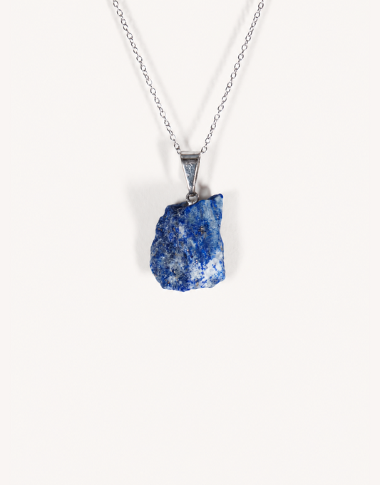 A Natural Raw Lapis Lazuli Pendant featuring an unpolished deep blue stone with golden pyrite flecks on an 18-inch stainless steel chain.