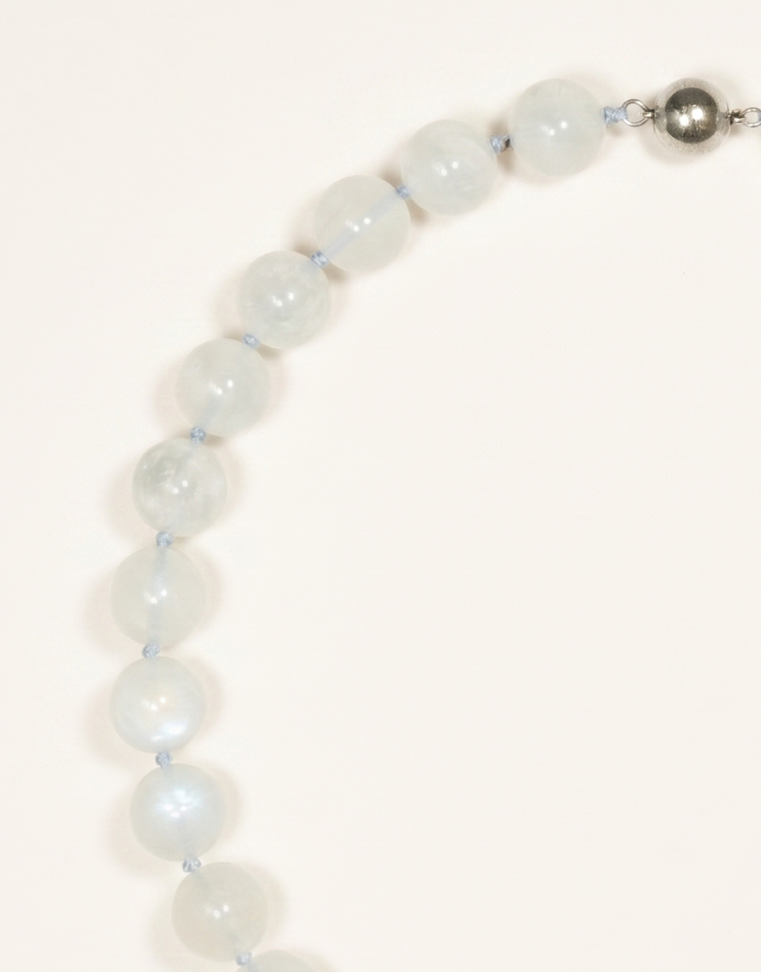 A 16-inch Natural Moonstone Choker showcasing smooth 12mm milky white beads with a soft floating blue flash.