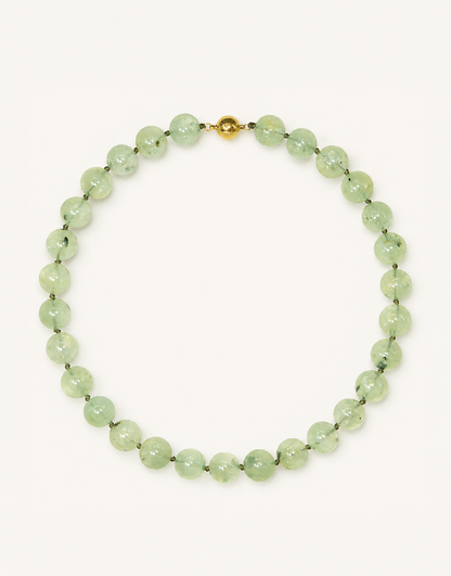 A 16-inch Natural Prehnite Choker featuring polished 12mm light green beads with unique dark tourmaline inclusions.