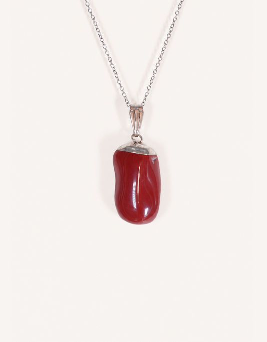 A Natural Red Jasper Pendant displaying a smooth, polished brick-red tumbled stone on an 18-inch stainless steel chain.