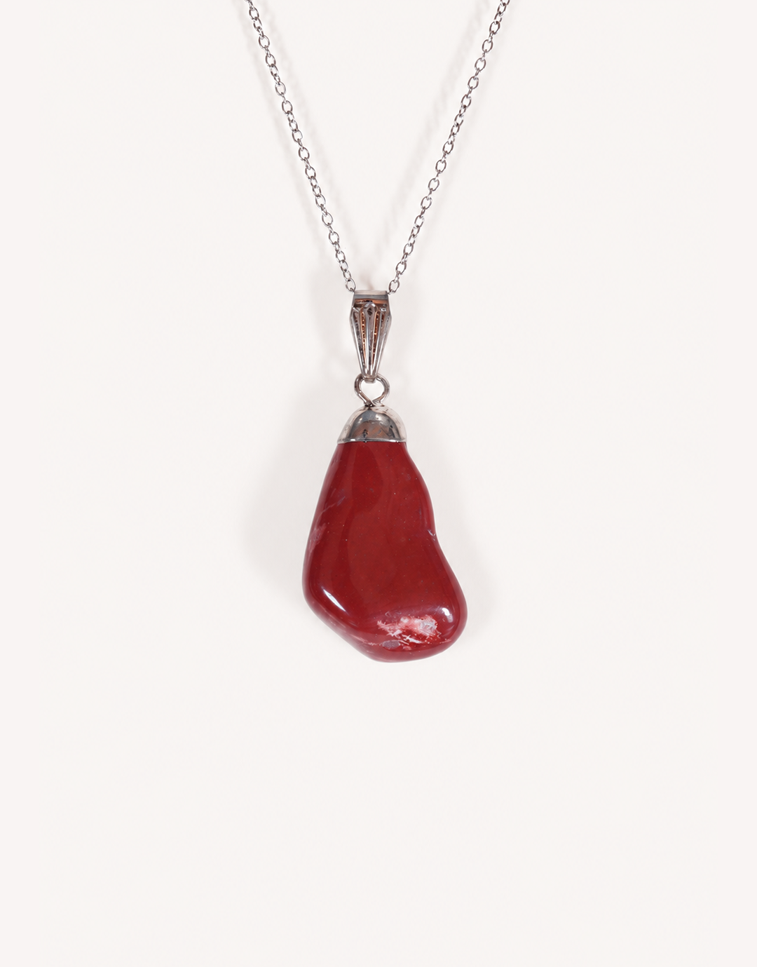 A Natural Red Jasper Pendant displaying a smooth, polished brick-red tumbled stone on an 18-inch stainless steel chain.