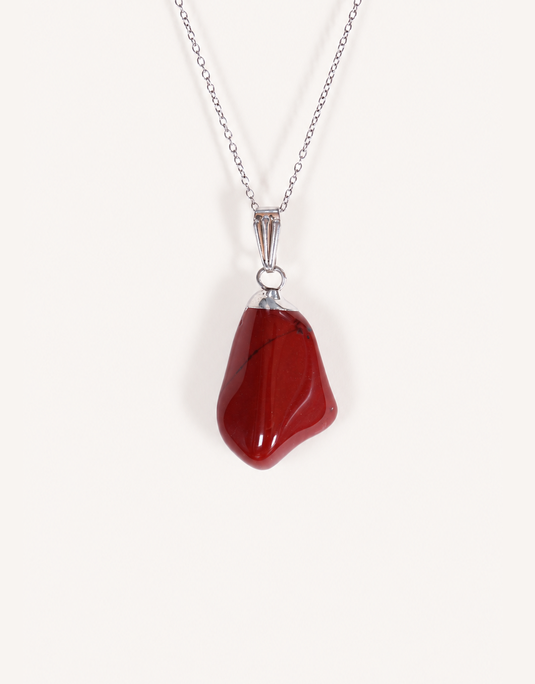A Natural Red Jasper Pendant displaying a smooth, polished brick-red tumbled stone on an 18-inch stainless steel chain.