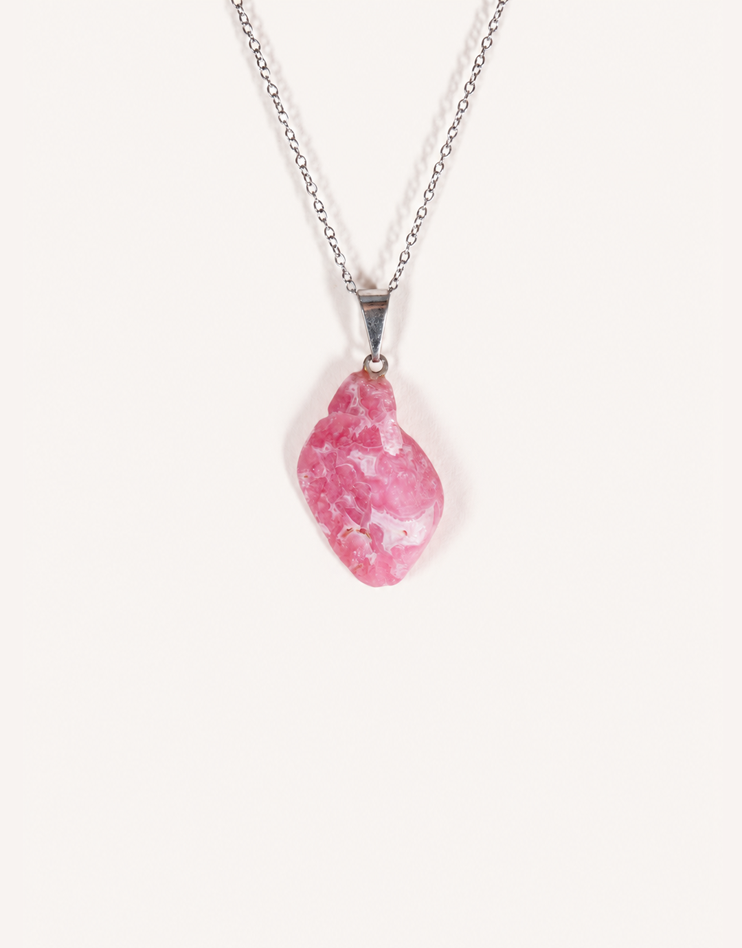 A Natural Rhodochrosite Pendant featuring a smooth pink stone with white banded ribbons on an 18-inch stainless steel chain.