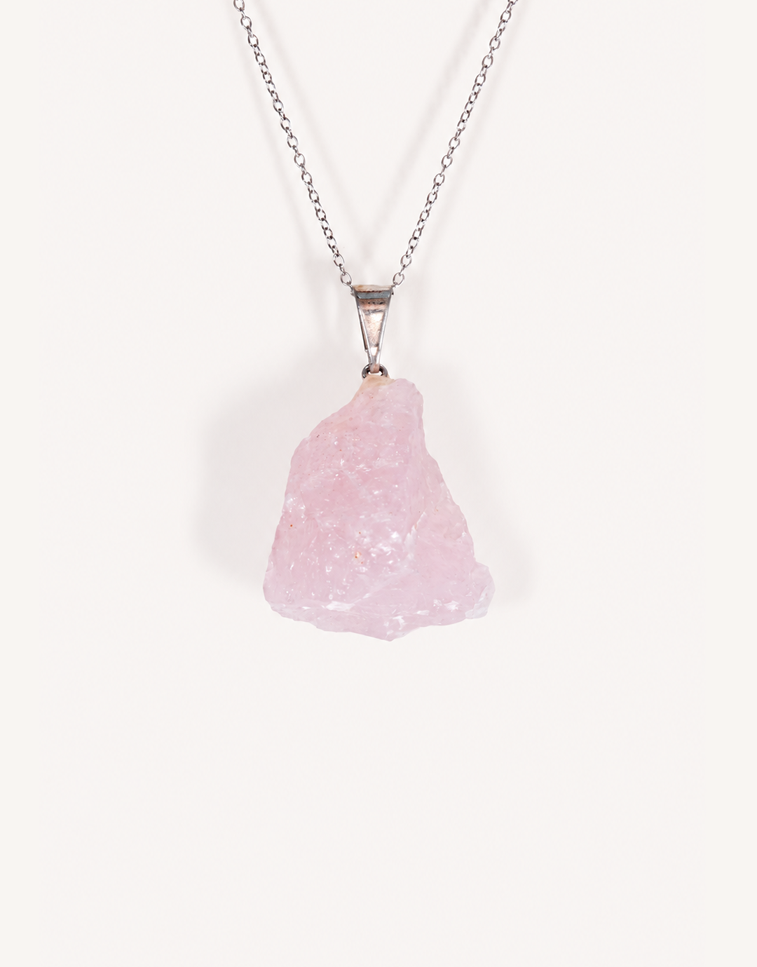 Natural raw rose quartz pendant showcasing rough blush-pink crystal texture on a complimentary 18-inch stainless steel chain.