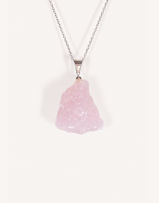 Natural raw rose quartz pendant showcasing rough blush-pink crystal texture on a complimentary 18-inch stainless steel chain.