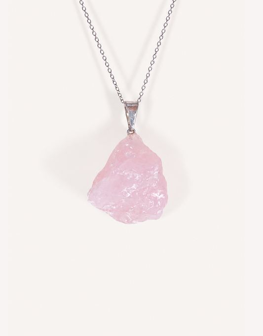 Natural raw rose quartz pendant showcasing rough blush-pink crystal texture on a complimentary 18-inch stainless steel chain.