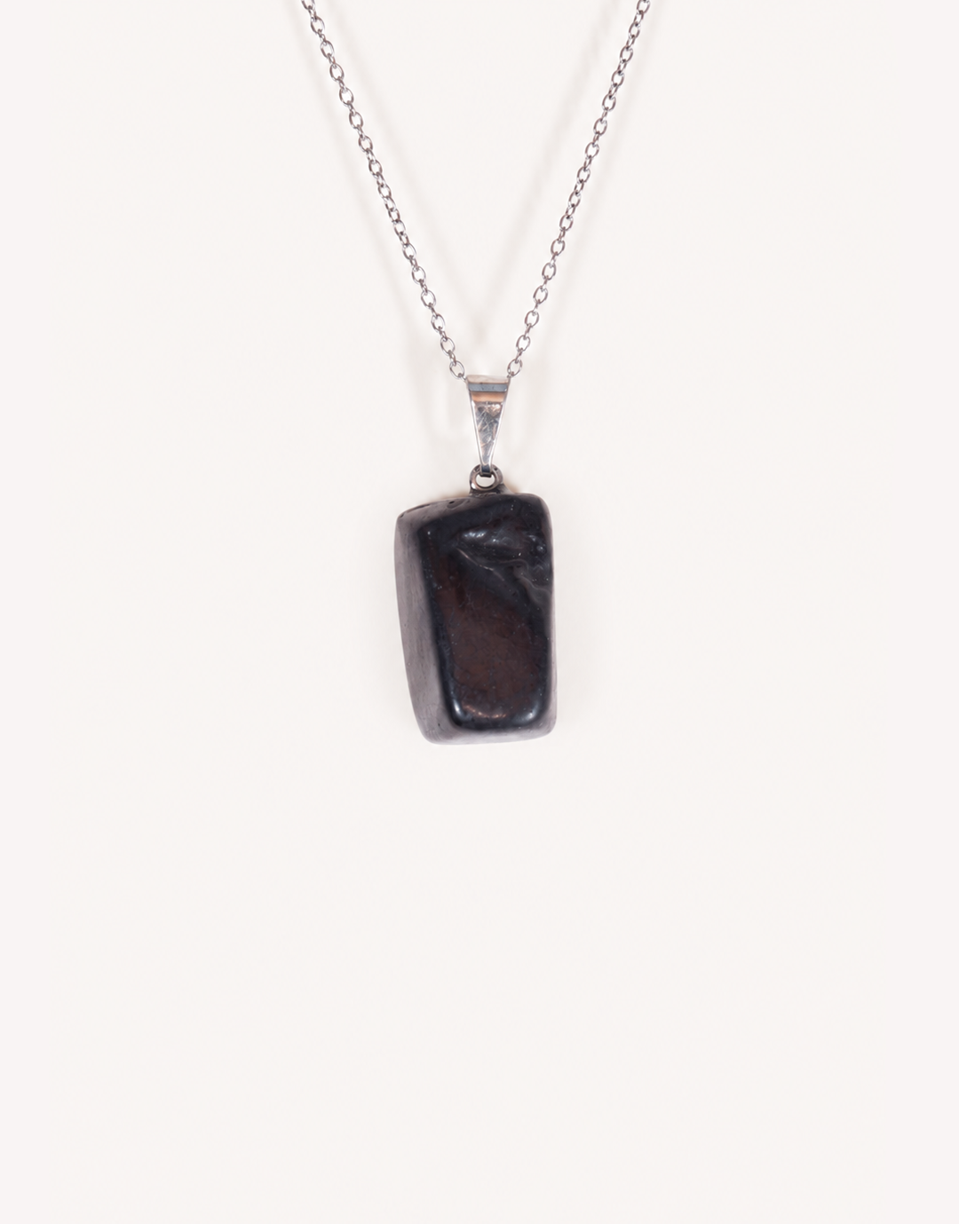 A Natural Shungite Pendant featuring a smooth graphite-black tumbled stone on an 18-inch stainless steel chain.
