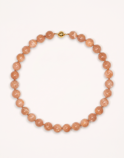 A 16-inch Natural Sunstone Choker crafted with polished 12mm beads in warm peach and terracotta tones with subtle metallic sparkle.