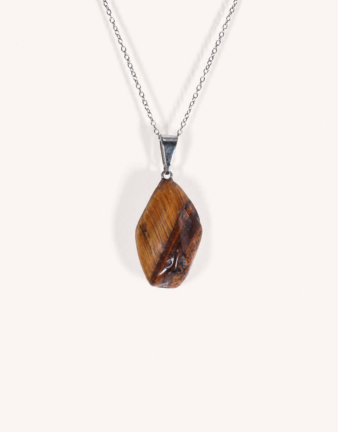 A Natural Freeform Tiger's Eye Pendant in a unique organic shape displaying golden-brown chatoyant shimmer on an 18-inch stainless steel chain.