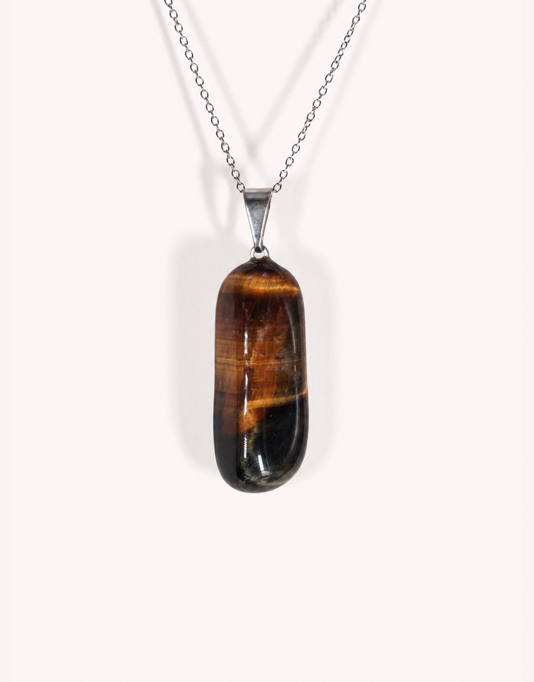 A Natural Freeform Tiger's Eye Pendant in a unique organic shape displaying golden-brown chatoyant shimmer on an 18-inch stainless steel chain.