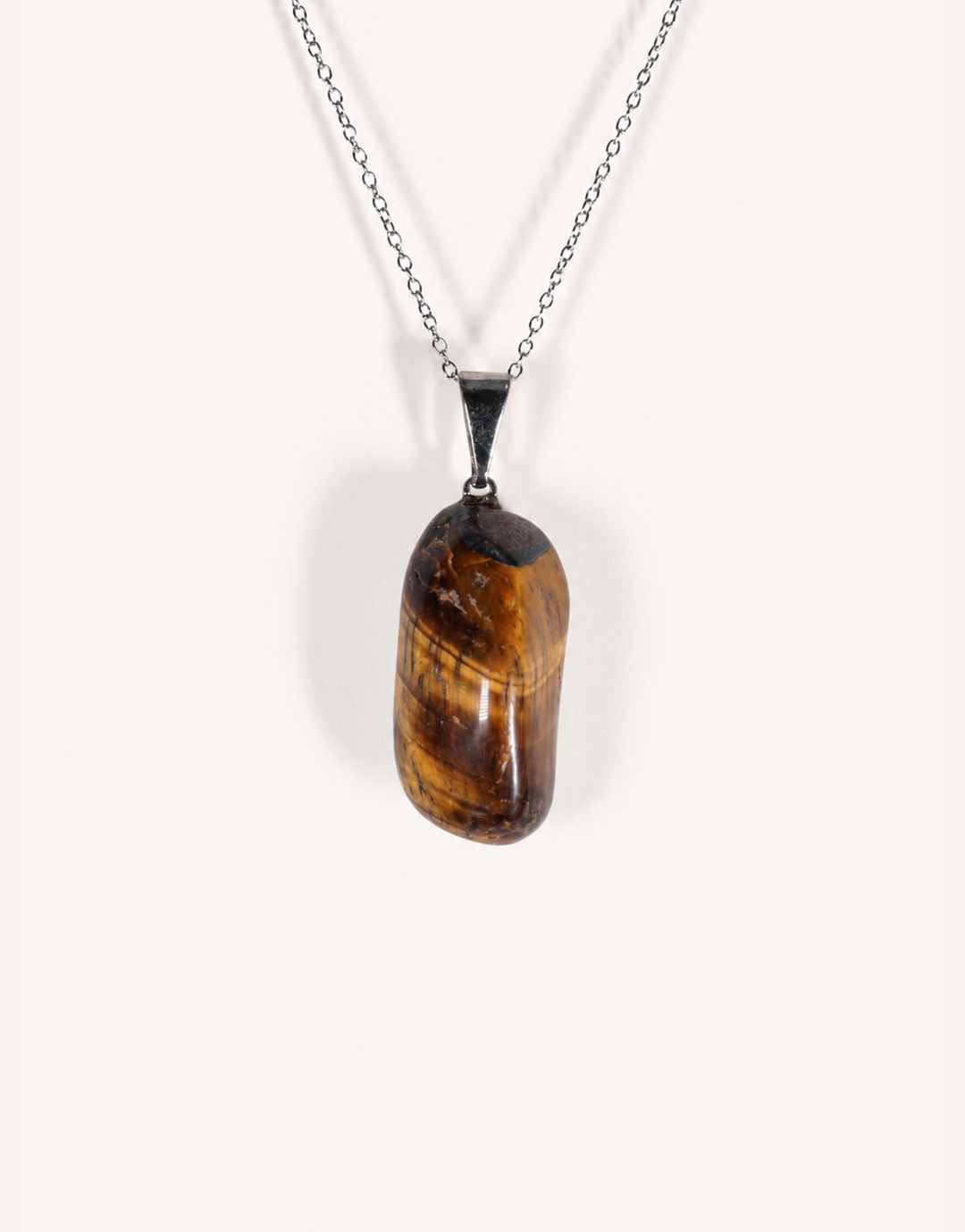 A Natural Freeform Tiger's Eye Pendant in a unique organic shape displaying golden-brown chatoyant shimmer on an 18-inch stainless steel chain.