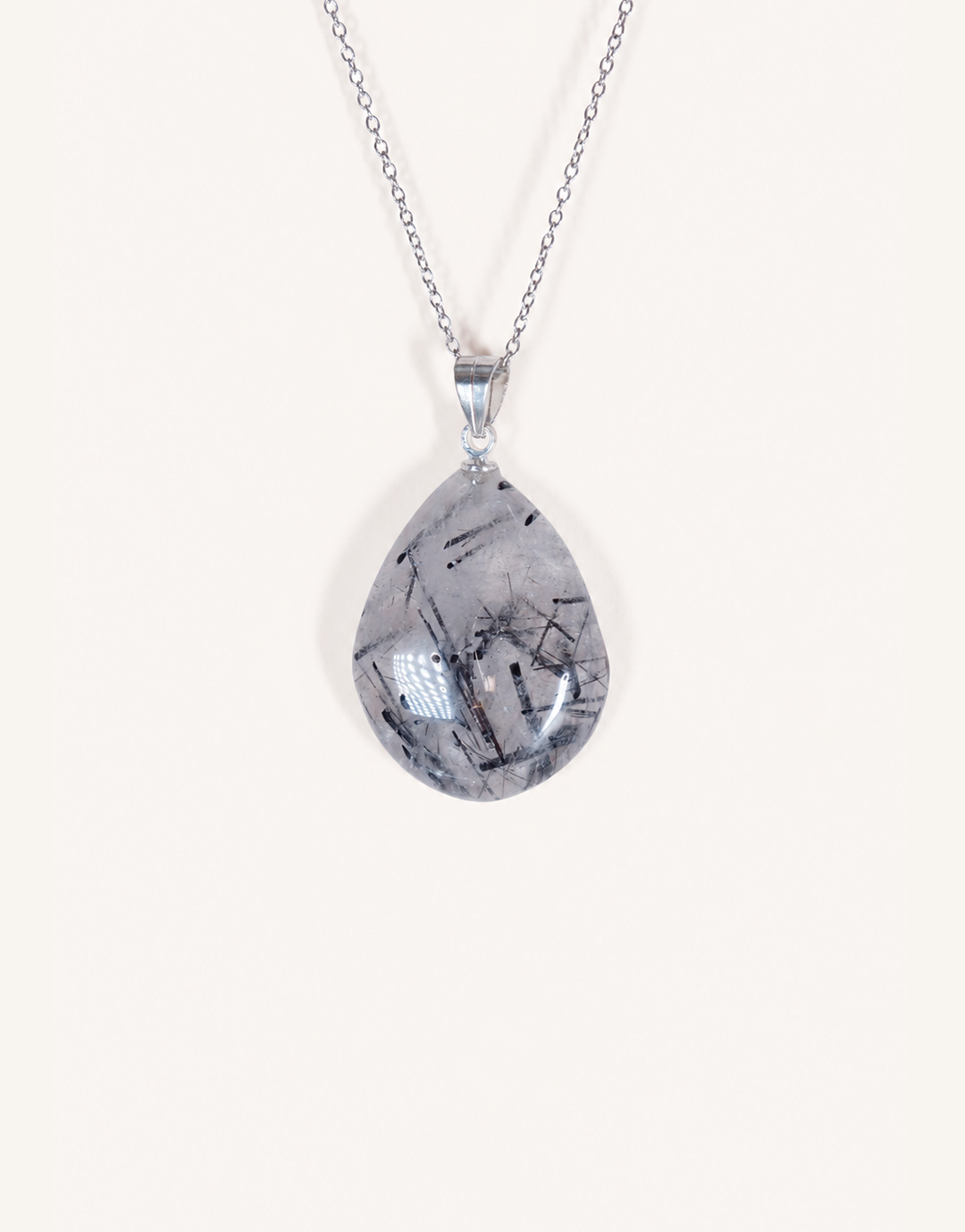 A Natural Tourmalinated Quartz Pendant showcasing clear quartz with black tourmaline needle inclusions on an 18-inch stainless steel chain.