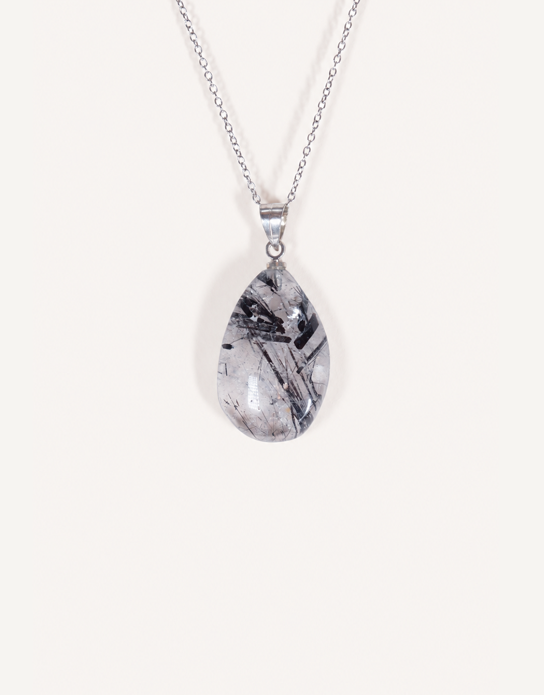 A Natural Tourmalinated Quartz Pendant showcasing clear quartz with black tourmaline needle inclusions on an 18-inch stainless steel chain.