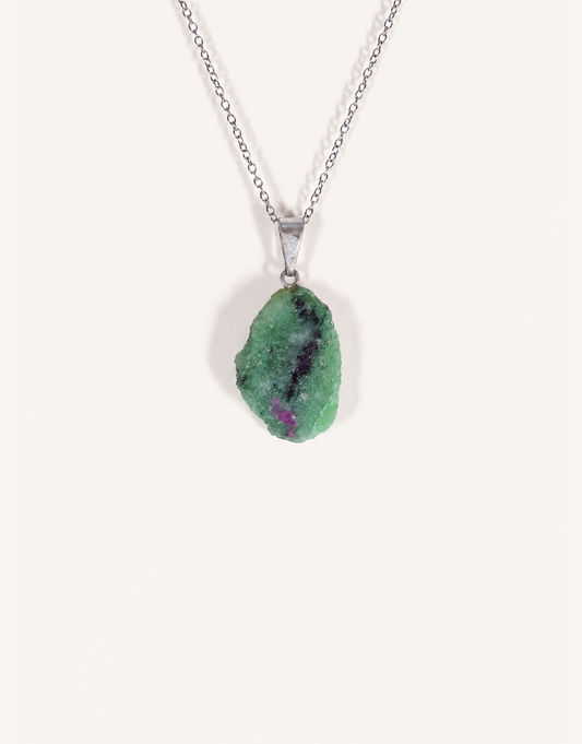 A Natural Raw Zoisite Pendant featuring a rough green crystal stone with black inclusions and a magenta ruby matrix spot on an 18-inch stainless steel chain.