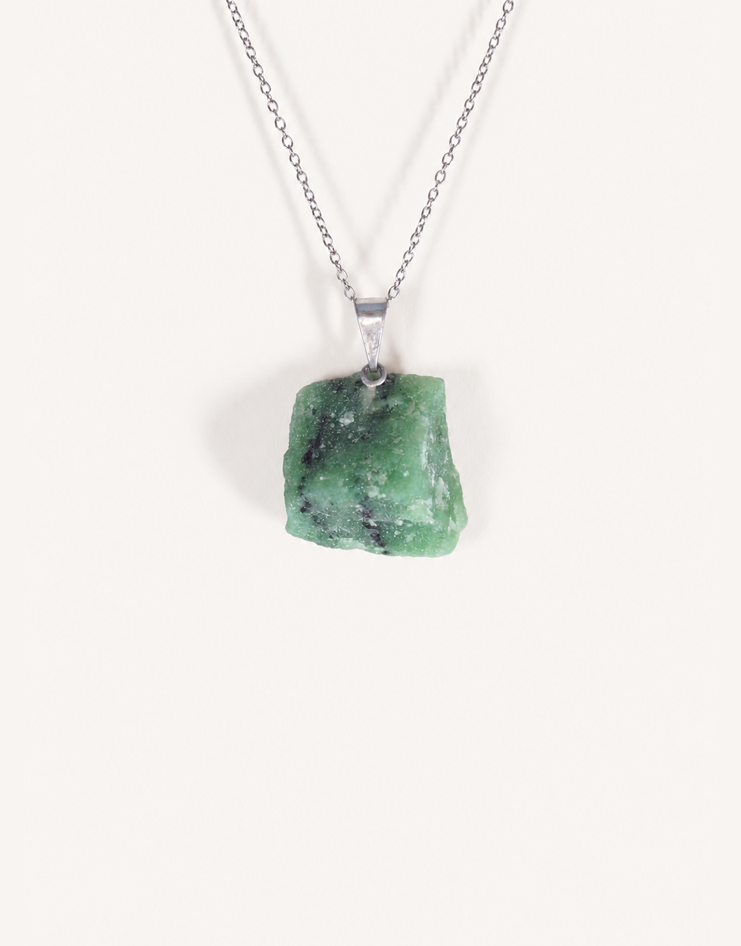 A Natural Raw Zoisite Pendant featuring a rough green crystal stone with black inclusions and a magenta ruby matrix spot on an 18-inch stainless steel chain.