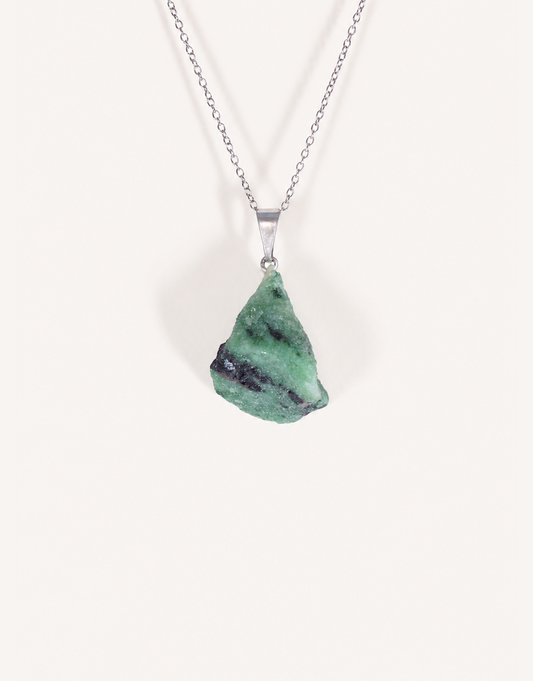 A Natural Raw Zoisite Pendant featuring a rough green crystal stone with black inclusions and a magenta ruby matrix spot on an 18-inch stainless steel chain.