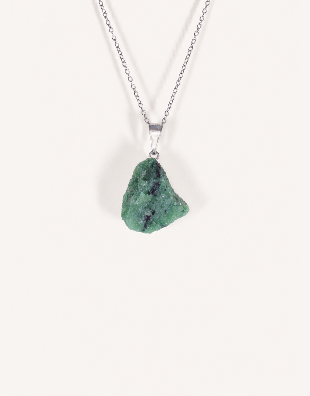 A Natural Raw Zoisite Pendant featuring a rough green crystal stone with black inclusions and a magenta ruby matrix spot on an 18-inch stainless steel chain.